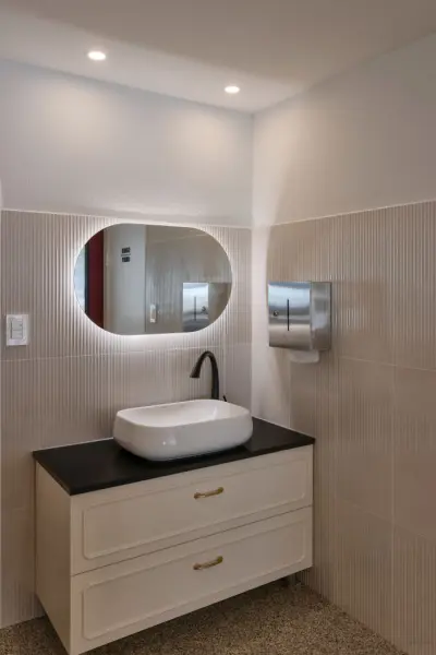 플로팅 세면대와 오벌 거울이 돋보이는 모던 화장실